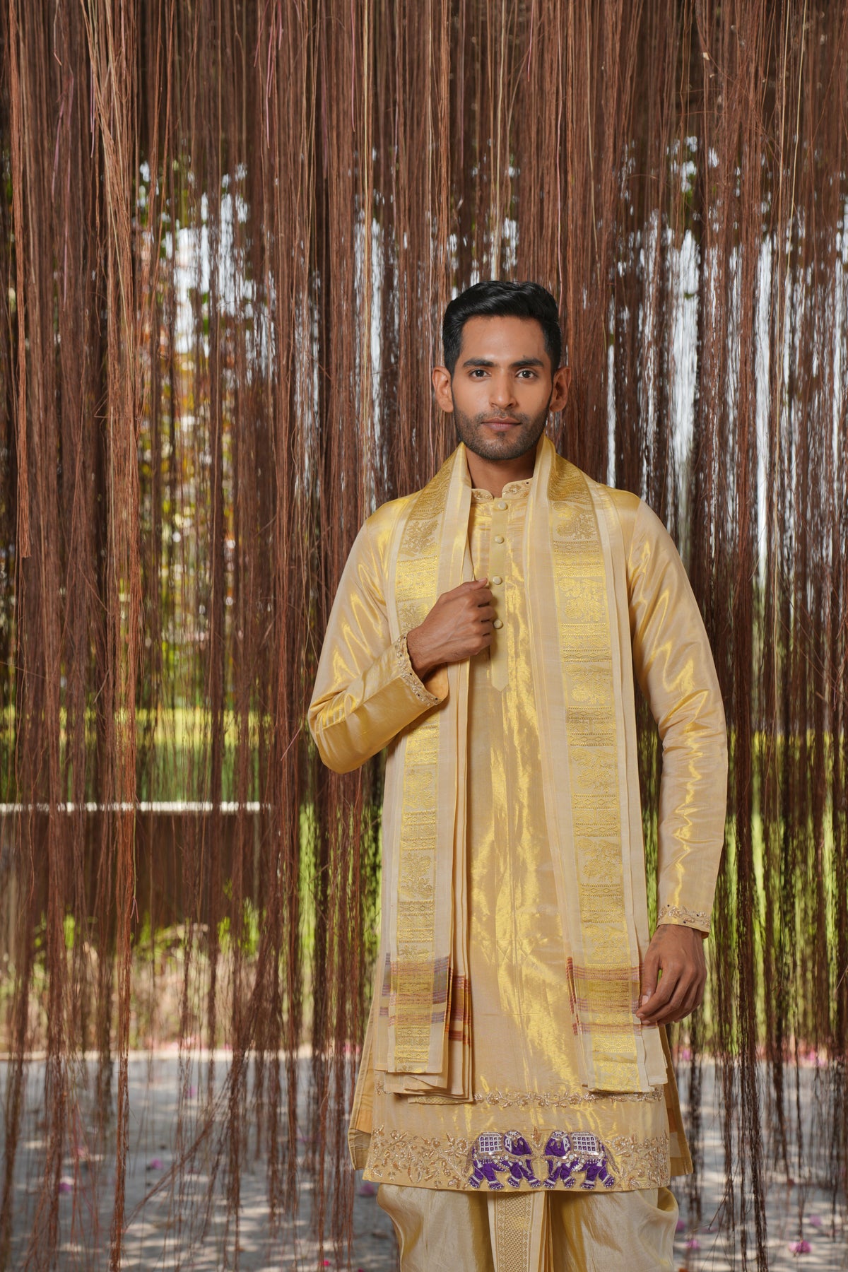 Close-up of hand-embroidered elephants on a gold pattu kurta
